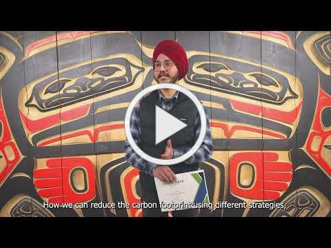 Video still from Coast Mountain College: a presenter in front of a carved First Nations panel