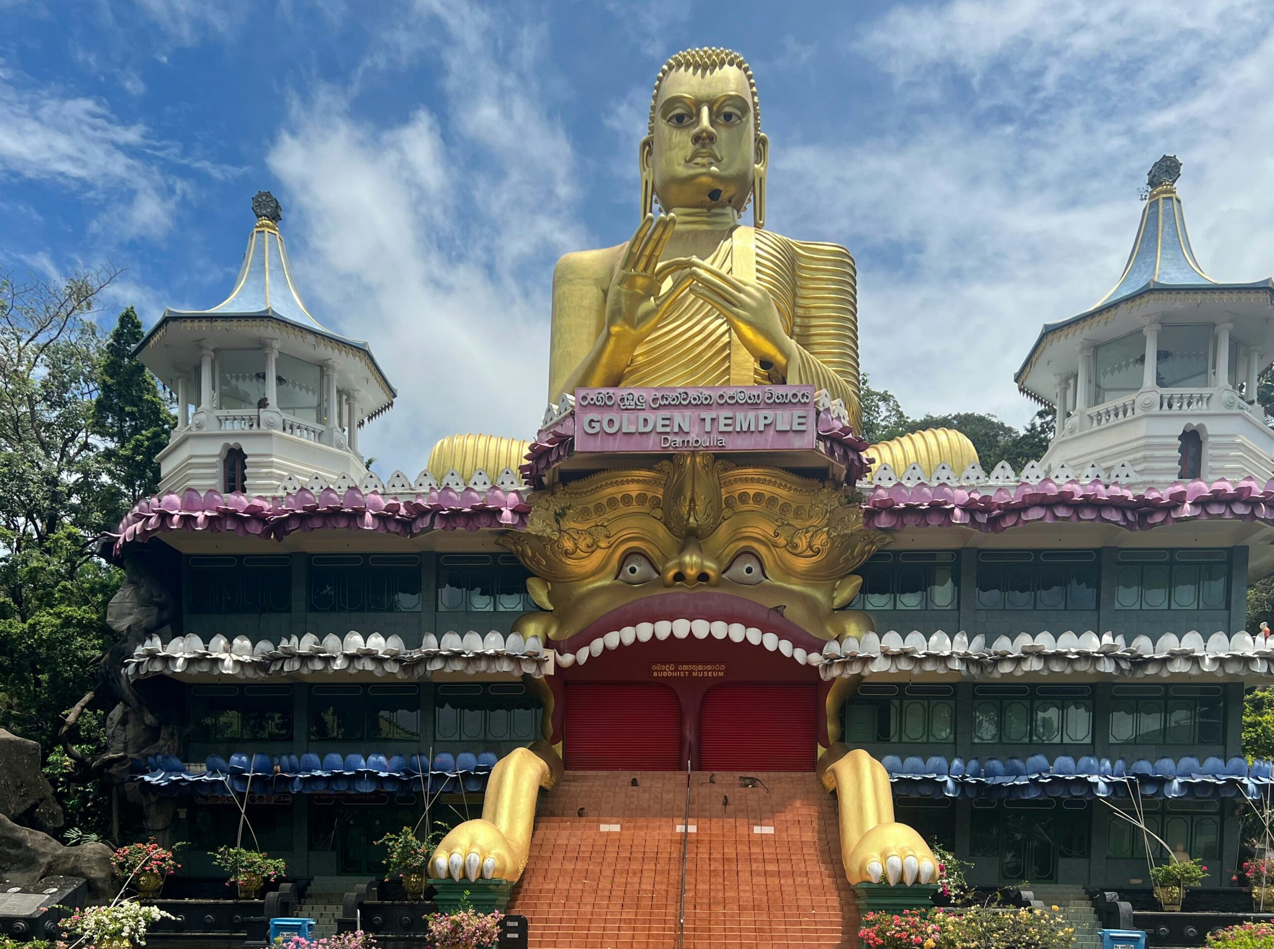 The golden Buddha statue and ornate facade of Dambulla's Golden Temple in Sri Lanka