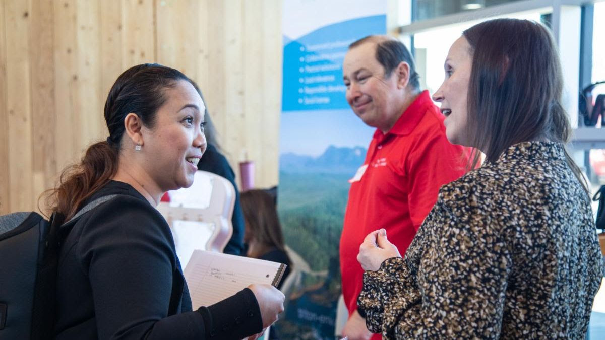 Students and staff in conversation at a campus information session