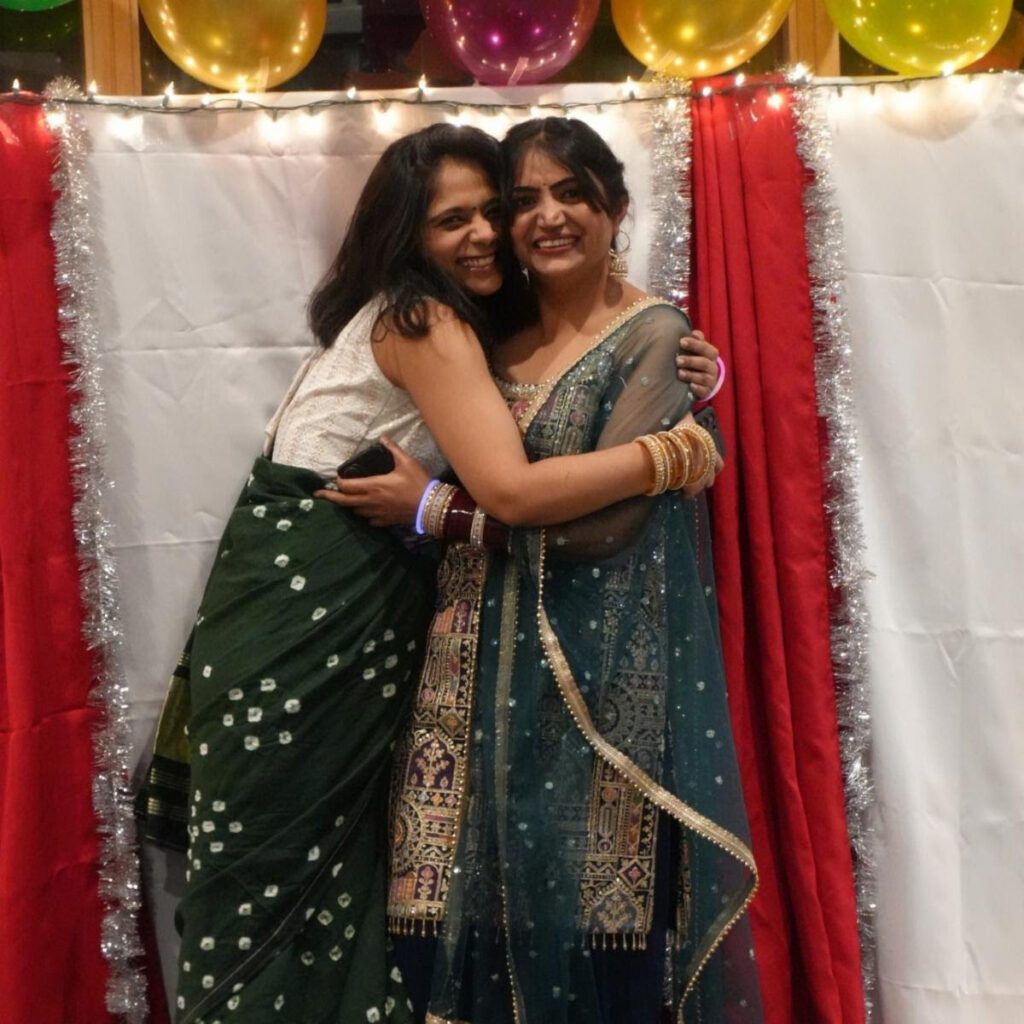Two students embracing at the Diwali photo wall