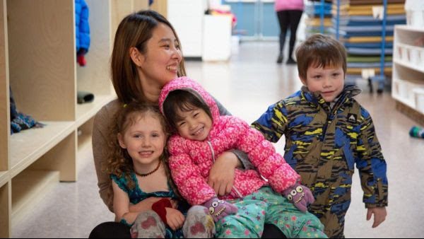A parent and children reading together