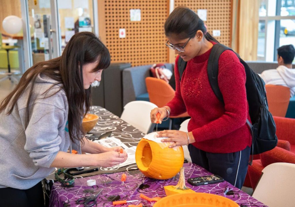 Students hollowing out and carving pumpkins